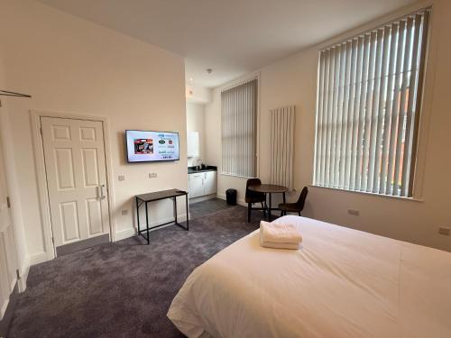 a bedroom with a bed and a flat screen tv at Fishergate Residences in Preston