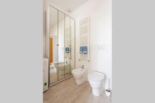 Baño blanco con aseo y lavamanos en Riva Reno Apartment, en Bolonia