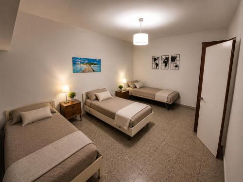 a hotel room with two beds and a table and two lamps at La Casa de Miel in Villa Ballester