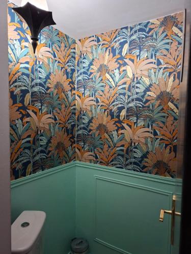 a bathroom with a wall with a blue and orange wallpaper at Romantic house by the River in Pfaffenhoffen
