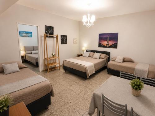 a room with two beds and a table and chairs at La Casa de Miel in Villa Ballester