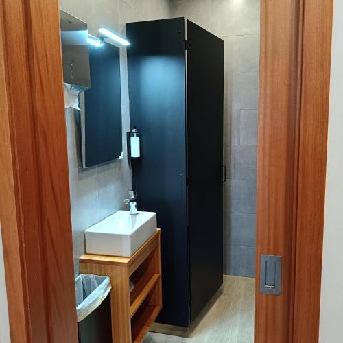 a bathroom with a white sink and a mirror at Santa Alegria Hostel in Ponta Delgada