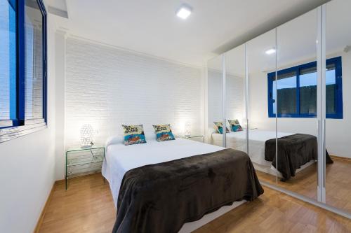 a bedroom with a large bed and a mirror at Suites Garden Apartamento 18 in Las Palmas de Gran Canaria