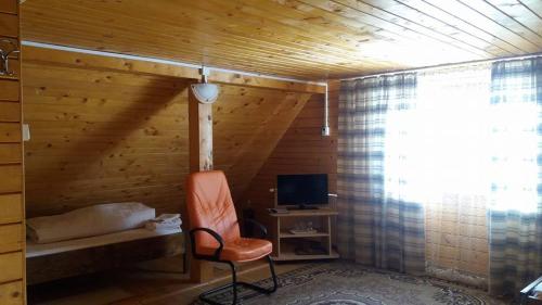 a room with a chair and a television in a room at Pensiunea Casa Motilor in Bucium
