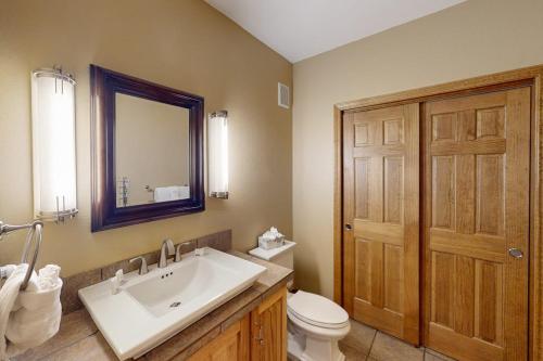 a bathroom with a sink and a toilet and a mirror at Blue River Bliss in Silverthorne