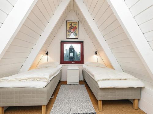 a attic room with two beds and a mirror at 4 star holiday home in Farsø in Farsø