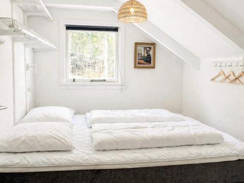 two beds in a white room with a window at Bright Cottage with Hot Tub in Ebeltoft