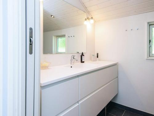 a white bathroom with a sink and a mirror at 5 star holiday home in Kolding in Kolding