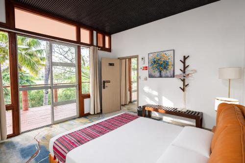 a bedroom with a bed and a large window at Rainbow Holiday Resort in Nadi