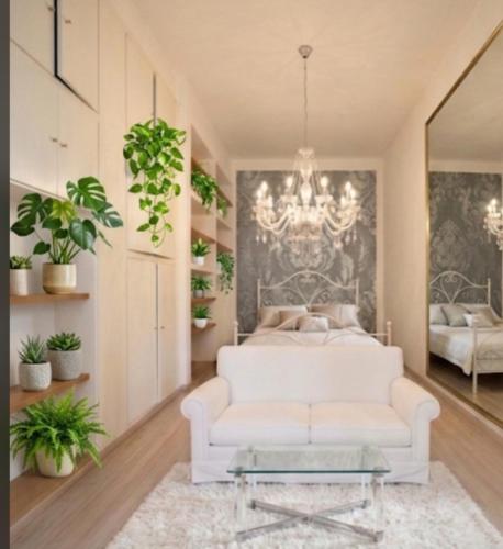 a living room with a white couch and a bed at Visconti suite and spa in Catania