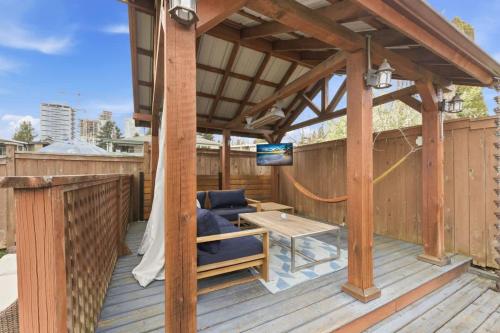 a pergola on a deck with a couch and a table at Bright Coquitlam Home & Spacious Backyard in Coquitlam