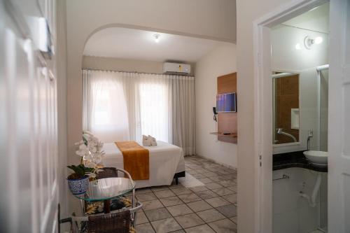 a hotel room with a bed and a bathroom at Hotel Portal do Descobrimento in Porto Seguro