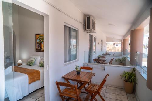 a room with a bed and a table and chairs at Hotel Portal do Descobrimento in Porto Seguro