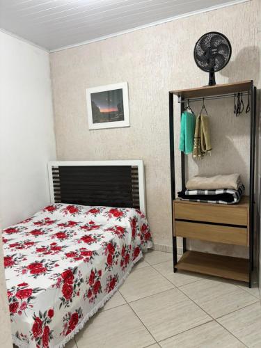 a bedroom with a bed and a dresser with a bed sidx sidx sidx sidx at Kitnet Encanto Astral in São Thomé das Letras