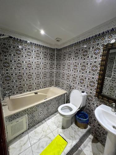 a bathroom with a tub and a toilet and a sink at Golden house in El Jadida