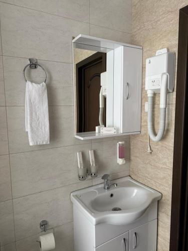 a bathroom with a sink and a mirror at Monroe Hotel in Almaty