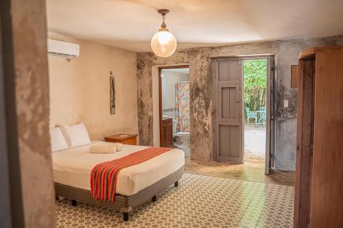 a bedroom with a bed and a bathroom at Charming Yellow Colonial House in the Downtown in Valladolid