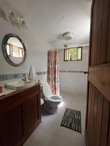 a bathroom with a toilet and a sink and a mirror at Charming Yellow Colonial House in the Downtown in Valladolid