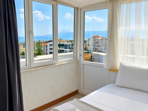 a bedroom with a bed and windows with a view at Luna Hotel in Antalya