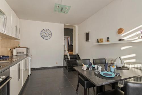 une cuisine et une salle à manger avec une table et des chaises dans l'établissement B&B Leopold Appartementen & studio's, à Saint-Trond