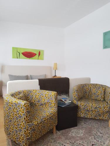 a living room with two chairs and a table at Weinek's Kellerstöckl u. Lodge in Güssing