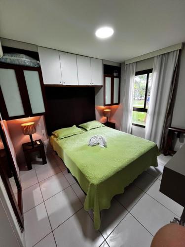 a bedroom with a bed with a green bedspread at VG Cumbuco J&Y in Caucaia
