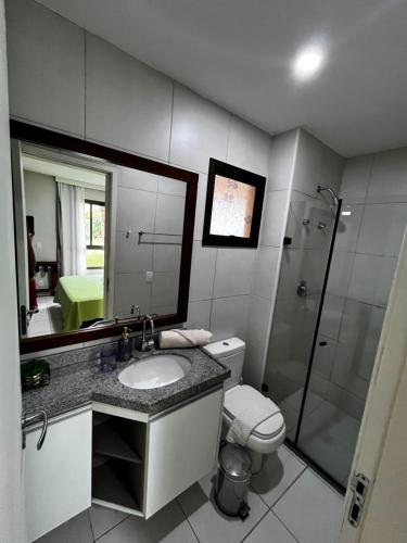 a bathroom with a sink and a toilet and a mirror at VG Cumbuco J&Y in Caucaia
