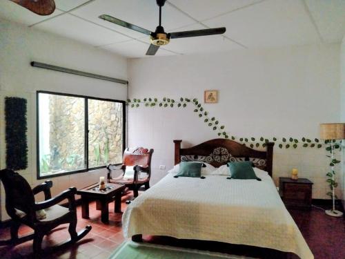 a bedroom with a bed and a ceiling fan at Templo Verde Eco hostal in Minca