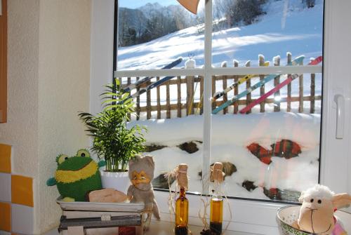 a window with a bunch of stuffed animals on a counter at Ferienhaus Niedernsill in Niedernsill