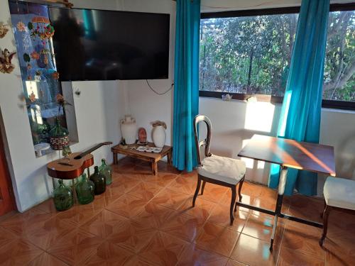 a living room with a television and a table and chairs at Geranio Bed & Breakfast in Casablanca