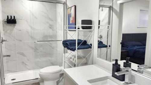 a bathroom with a shower and a toilet and a sink at TNC Stays Luxurious Modern Suite Seton Calgary South in Calgary
