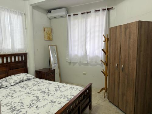 a bedroom with a bed and a wooden cabinet at Cabaña Mar Olon Renovation in Olón