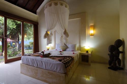 a bedroom with a bed and a large window at Villa Nusa in Nusa Dua