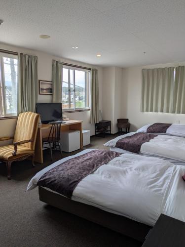 a hotel room with two beds and a desk with a computer at Fuji Mountain Resort Hotel in Fujikawaguchiko