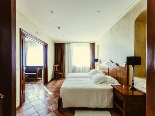CintruénigoにあるHotel Maherの大きなベッドとデスクが備わるホテルルームです。