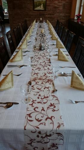 a long table with a white table cloth with wine glasses at Il Gallo Nero - Fekete Kakas Étterem és Panzió in Szombathely