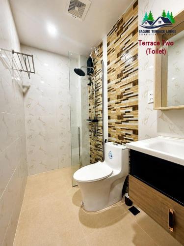 a bathroom with a toilet and a sink and a shower at Baguio Terrace Lodge in Baguio