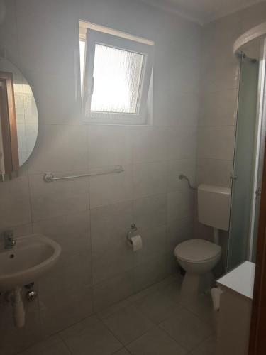 a bathroom with a toilet and a sink and a window at Sobe Ivan-Popić in Međugorje
