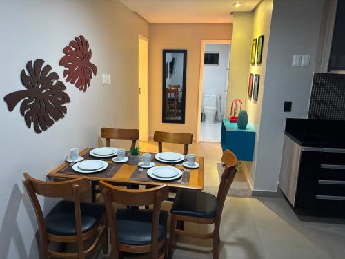 a dining room with a wooden table and chairs at Suites Coliseu 40-A in Petrolina