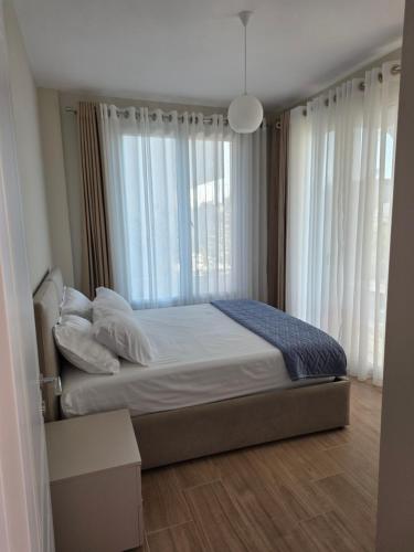 a bedroom with a bed and a large window at Villa Gala - First Floor Apartment in Draç