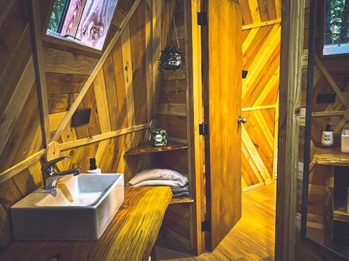 a bathroom with a sink in a wooden house at Lodge Domos Awen in Pucón
