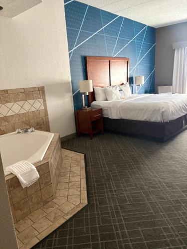 a hotel room with a bed and a bath tub at Comfort Suites Richmond in Richmond