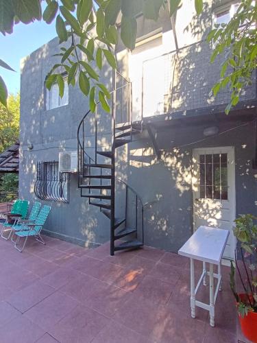 a patio with a spiral staircase next to a building at Siempre verde3 in Merlo