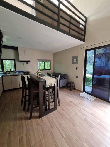 a kitchen and living room with a table and chairs at Villa 1991 in San Ignacio
