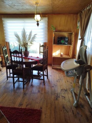 a dining room with a table and chairs and a room with a camera at Puñañas descanso y experiencias in Vilcún