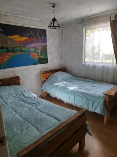 a bedroom with two beds and a window at Puñañas descanso y experiencias in Vilcún