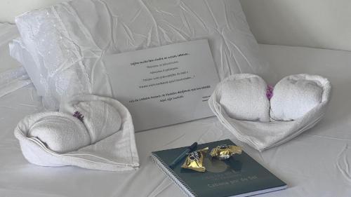 a couple of hearts and a book on a bed at Cenário Perfeito para Seu Dia Especial: Chácara Recanto do Pinheiro in Capão do Leão