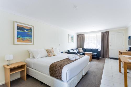 a hotel room with a bed and a living room at Emu Point Motel in Albany