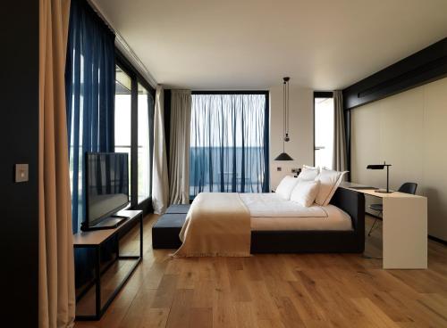 a hotel room with a bed and a television at Sense Hotel Sofia, a Member of Design Hotels in Sofia