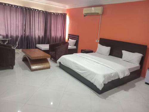 a bedroom with a bed and a chair and a table at Light house hotel lekki phase 1 in Araromi